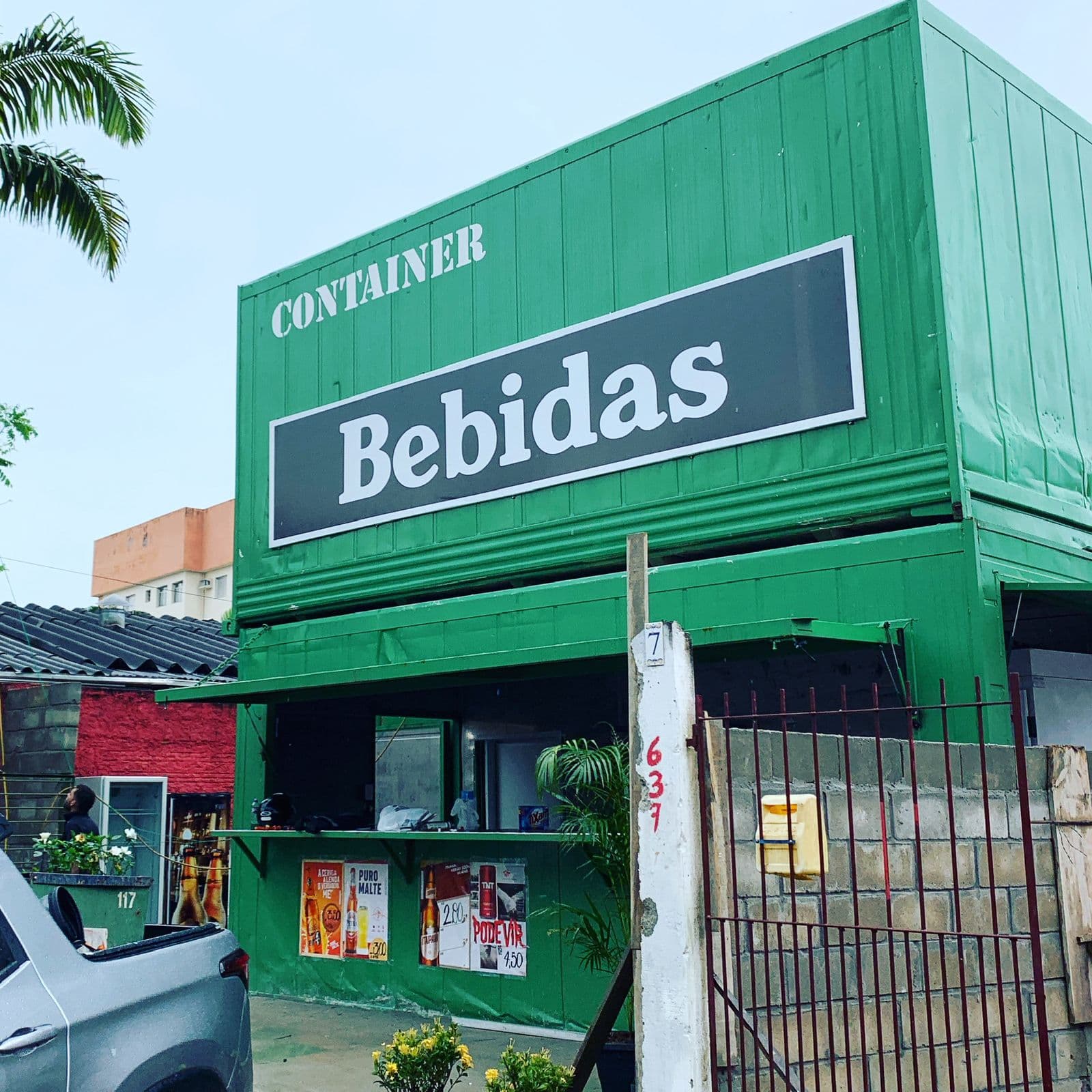 Container verde com fachada de bebidas em ambiente urbano