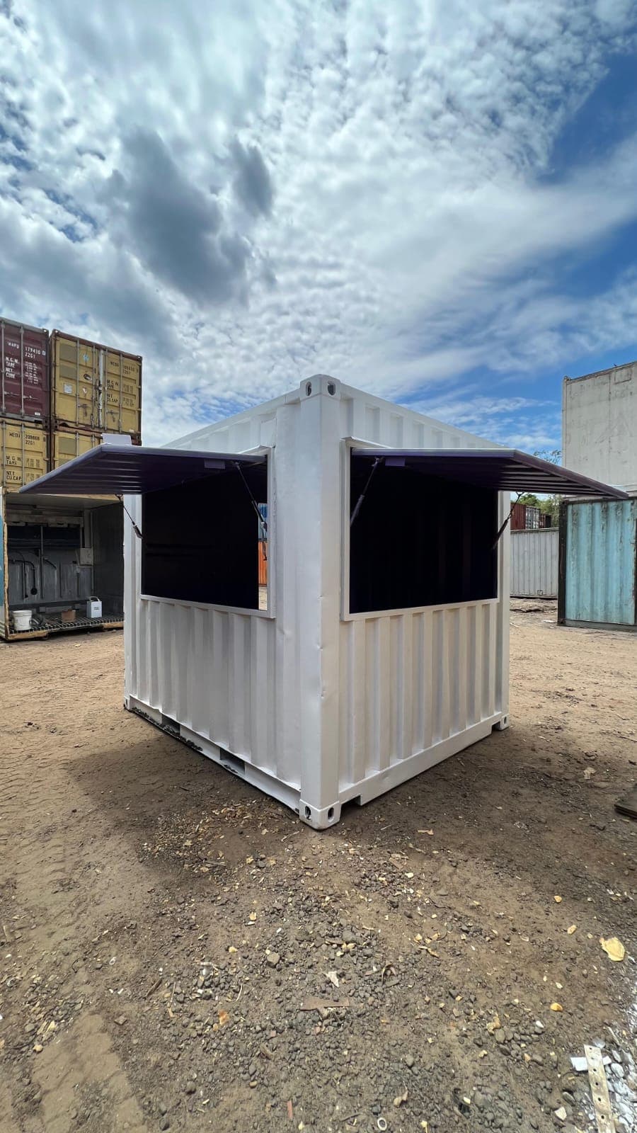 Container branco com janelas basculantes abertas para atendimento
