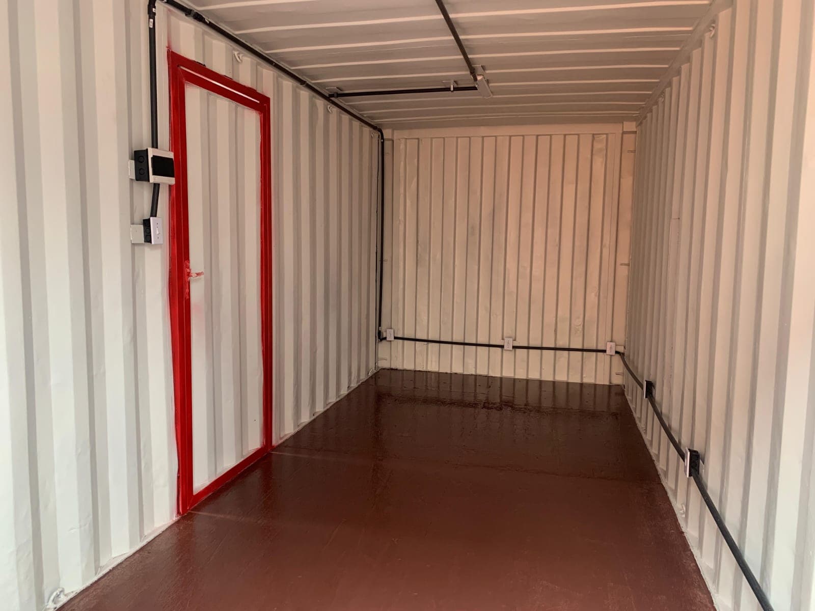 Interior de container com infraestrutura elétrica e acabamento industrial