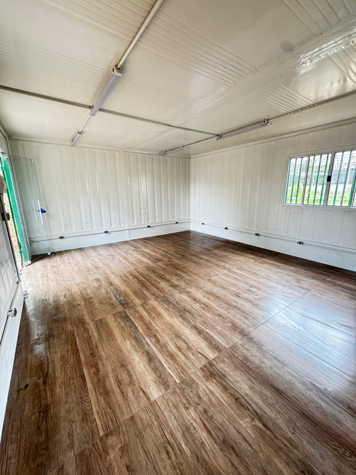 Espaço interno com acabamento em piso amadeirado e iluminação linear